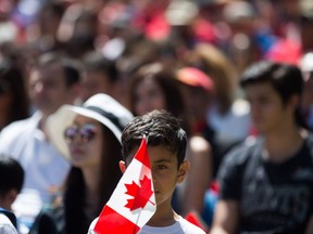 A young boy holds a Canadian flag while watching a Canada Day citizenship ceremony in West Vancouver last year.