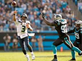 Russell Wilson of the Seattle Seahawks throws under pressure from Mario Addison of the Carolina Panthers.