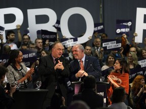 B.C. Green party Leader Andrew Weaver (left) and NDP Premier John Horgan, shown at a Victoria rally on Oct. 23, are in favour of proportional representation.