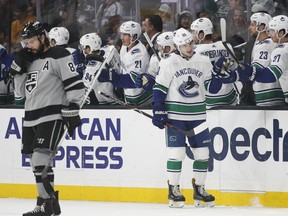 Vancouver Canucks' Adam Gaudette, center, celebrates his goal with teammates as Los Angeles Kings' Drew Doughty skates near them during the second period of an NHL hockey game Saturday, Nov. 24, 2018, in Los Angeles.