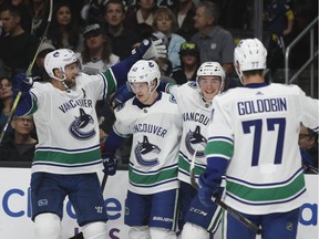 Vancouver Canucks' Alexander Edler, from left, Elias Pettersson, Jake Virtanen and Nikolay Goldobin celebrate a goal by Pettersson during the third period of an NHL hockey game against the Los Angeles Kings Saturday, Nov. 24, 2018, in Los Angeles. The Canucks won 4-2.