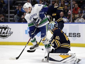 Jake Virtanen, who potted his seventh goal, tries to screen Carter Hutton.
