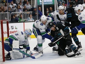 Vancouver Canucks' netminder Anders Nilsson makes a save against San Jose Sharks' Joe Pavelski with the help of Canucks' defenceman Chris Tanev and Michael Del Zotto during Friday's NHL game in San Jose, Calif. San Jose won 4-0.