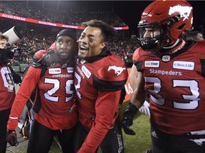 Calgary Stampeders defensive back Jamar Wall (29), defensive back Patrick Levels (3) and linebacker Eric Mezzalira (33) celebrate an interception against the Ottawa Redblacks during the second half of the 106th Grey Cup at Commonwealth Stadium in Edmonton, Sunday, November 25, 2018.