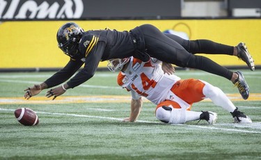 Hamilton Tiger-Cats defensive end Adrian Tracy (5) dives over B.C. Lions quarterback Travis Lulay (14) to recover a fumbled during first half CFL Football division semifinal game action in Hamilton, Ont. on Sunday, November 11, 2018.