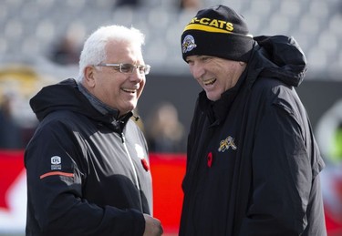Hamilton Tiger-Cats head coach June Jones, right, laughs with B.C. Lions head coach Wally Buono during warm-up before CFL Football division semifinal game action in Hamilton, Ont. on Sunday, November 11, 2018.