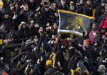 Hamilton Tiger-Cats fans try to catch a ball thrown into the stands by Hamilton wide receiver Luke Tasker (17) after his first touchdown of the game during first half CFL Football division semifinal game action against the B.C. Lions in Hamilton, Ont. on Sunday, November 11, 2018.