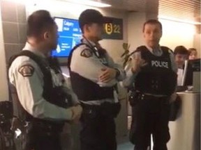 RCMP officers are seen at a Vancouver airport gate Tuesday, Nov. 20, 2018 in this image made from video. RCMP officers were called to a Vancouver airport gate Tuesday night to explain the re-booking and accommodation options to Flair Airlines passengers — some of whom had been waiting 14 hours — a job typically handled by airline staff.