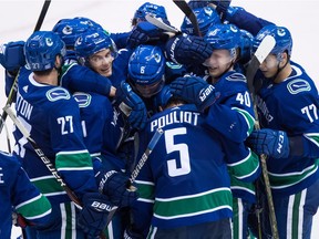 Vancouver Canucks' Ben Hutton (27), Loui Eriksson (21), of Sweden, Brock Boeser (6), Derrick Pouliot (5), Elias Pettersson (40), of Sweden, and Nikolay Goldobin (77), of Russia, celebrate Pouliot's winning goal during overtime NHL hockey action in Vancouver, on Friday November 2, 2018.