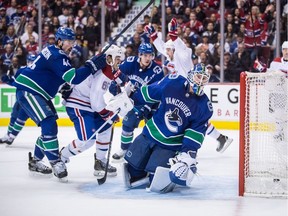 Vancouver Canucks goalie Jacob Markstrom, front right, of Sweden, looks on as Montreal Canadiens' Jonathan Drouin, back centre, celebrates his goal while Vancouver's Erik Gudbranson (44) and Montreal's Andrew Shaw (65) watch during third period NHL hockey action in Vancouver, on Saturday, Nov. 17, 2018.
