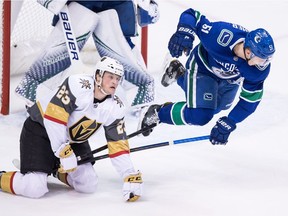 Troy Stecher gets tripped by Daniel Carr during the second period Thursday.