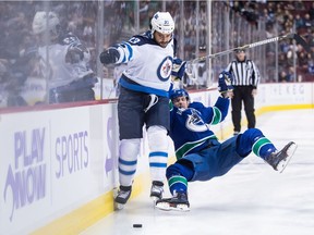 Winnipeg Jets' Dustin Byfuglien fights off Vancouver Canucks' Tim Schaller during the first period on Monday night.