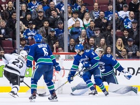 Los Angeles Kings' Dustin Brown (23) scores the winning goal against Vancouver Canucks goalie Jacob Markstrom, right, of Sweden, as Brock Boeser (6) and Chris Tanev (8) watch during overtime NHL hockey action in Vancouver, on Tuesday November 27, 2018.