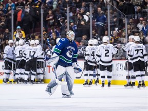 Los Angeles Kings' Jeff Carter, back left, trips over Vancouver Canucks goalie Jacob Markstrom, of Sweden, as Nikolay Goldobin (77), of Russia, watches during the second period of an NHL hockey game in Vancouver, on Tuesday November 27, 2018.