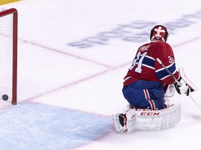 The puck sails into the net past Montreal Canadiens goaltender Carey Price on a goal by Buffalo Sabres' Rasmus Ristolainen during overtime in Montreal on Nov. 8, 2018.