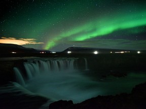 The aurora borealis, also known as Northern Lights, is seen over Godafoss waterfall, in the municipality of Thingeyjarsveit, east of Akureyri, in northern Iceland on October 14, 2018.