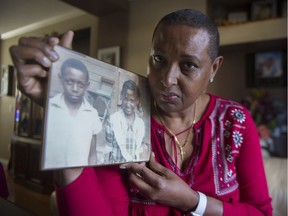 Veronica Harrison-Dawkins with a childhood photo of herself and her older (by a year) brother, Claude Allen. Eighteen years after Allen was shot and killed in a Kingsway dance hall, his family is seeking answers.