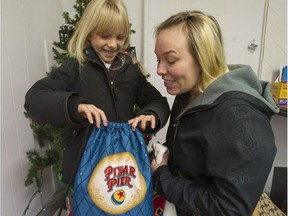 Tasha Nickles and her daughter Aria, 7, at the Surrey Christmas Bureau with items donated from The Province Empty Stocking Fund.