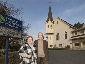 Joyce and Horst Flemig outside Trinity Lutheran Church in Delta, which has two bells. On Armistice Day 1918, local young men were so excited they climbed into the church bell tower and struck one of the bells with metal objects and pipes to make the bell ring louder. This cracked the bell. The since-silent bell has become a symbol of the joy that peace brought to the community.