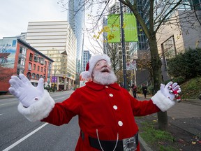 Santa in attendance as the last Santa Claus Parade banner is hung up on West Georgia street in Vancouver, Nov. 20, 2018.
