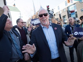 B.C. Premier John Horgan, right, walks to a mailbox with people mailing their electoral reform referendum ballots after a rally in Vancouver on Sunday, Nov. 18, 2018. A new poll suggests a dead heat in B.C. between those who want change and those who do not.