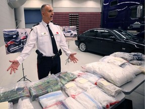 Insp. Max Waddell of the Winnipeg Police Service's organized crime unit displays some of the illicit drugs, cash and other items seized as part of an investigation that led to charges against several B.C. residents, among others. The B.C. government wants a house and several vehicles forfeited after their owners were charged with drug trafficking in Manitoba.