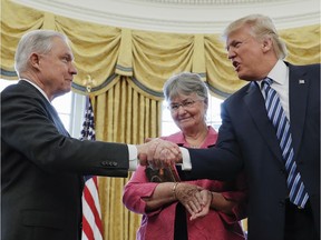 FILE - In this Feb. 9, 2017 file photo, President Donald Trump shakes hands with Attorney General Jeff Sessions, accompanied by his wife Mary, after he was sworn-in by Vice President Mike Pence, in the Oval Office of the White House in Washington. On Nov. 7, 2018, Sessions submitted his resignation in letter to Trump.