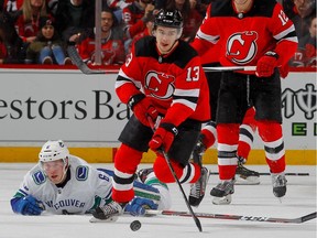 Nico Hischier #13 of the New Jersey Devils skates with the puck past Brock Boeser #6 of the Vancouver Canucks during the second period at Prudential Center on December 31, 2018 in Newark, New Jersey.