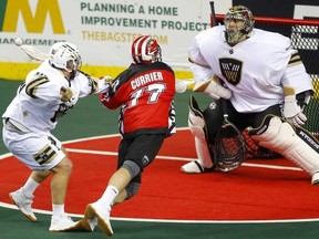 Calgary Roughnecks Zach Currier centre) collides with Vancouver Warriors Joel McCready left) as he tries to score on Warriors goalie Aaron Bold during their game at the Scotiabank Saddledome in Calgary, on Saturday Dec. 15, 2018.
