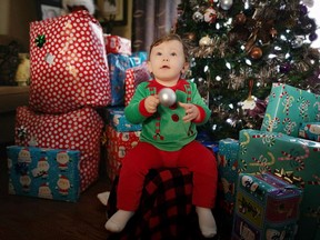 FILE PHOTO: Maxwell Vaillancourt, 11 months, sneaks an ornament off the tree while checking out the presents under the tree as he prepares to enjoy his first Christmas with parents Kaila and Josh Vaillancourt, grandparents and extended family.