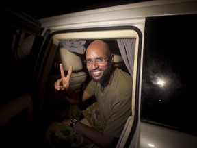 Saif al-Islam Kadhafi, son of Libyan leader Moamer Kadhafi, flashes the V-sign for victory as he appears in front of supporters and journalists in the Libyan capital Tripoli in the early hours of August 23, 2011.