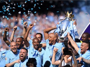 Manchester City captain Vincent Kompany hoists the Premier League Trophy as teammates celebrate their 2017-18 championship last May. Canadian sports cable networks TSN and Sportsnet won’t be sharing rights to broadcast the lucrative English soccer league next season.