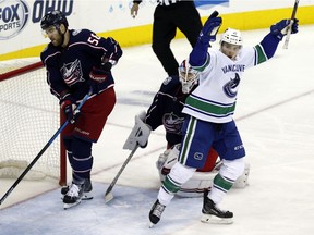 Vancouver Canucks forward Jake Virtanen, right, celebrates teammate forward Josh Leivo's goal in front of Columbus Blue Jackets defenseman David Savard, left, and goalie Joonas Korpisalo, of Finland, during the third period of an NHL hockey game in Columbus, Ohio, Tuesday, Dec. 11, 2018. The Canucks won 3-2.