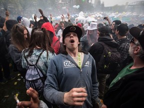 A man reacts while smoking a joint along with thousands of others during the 4-20 annual marijuana celebration, in Vancouver, B.C., on Friday April 20, 2018.