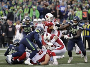 Players eye a loose ball fumbled by the Arizona Cardinals during the second half of an NFL football game against the Seattle Seahawks, Sunday, Dec. 30, 2018, in Seattle. The Seahawks recovered on the play.