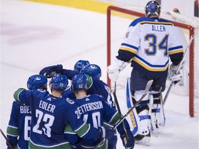 Members of the Vancouver Canucks celebrate teammate Vancouver Canucks center Bo Horvat's goal past St. Louis Blues goaltender Jake Allen (34) during second period NHL action at Rogers Arena in Vancouver, Thursday, Dec. 20, 2018.