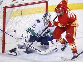 Vancouver Canucks goalie Jacob Markstrom makes a save against Calgary Flames' TJ Brodie during third period NHL action in Calgary on Saturday night. The goalie stood tall in the Canucks' OT victory.