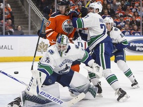 Jacob Markstrom  makes the save as Connor McDavid and Ben Hutton battle in the second period.