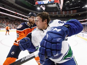 Vancouver Canucks' Jay Beagle, right, and the Oilers' Adam Larsson battle for the puck during NHL action in Edmonton on Dec. 27, 2018.