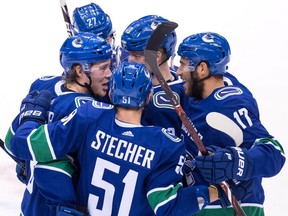 Vancouver Canucks' Brock Boeser, clockwise from left, Ben Hutton, Elias Pettersson, of Sweden, Josh Leivo and Troy Stecher celebrate Boeser's goal against the Philadelphia Flyers during the second period of an NHL hockey game in Vancouver, on Saturday December 15, 2018.