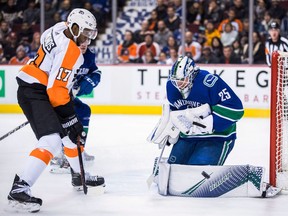 Vancouver Canucks goalie Jacob Markstrom, right, of Sweden, makes a save as Philadelphia Flyers' Wayne Simmonds watches during the first period of an NHL hockey game in Vancouver, on Saturday December 15, 2018.