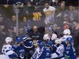 Hockey fans look on as members of the Vancouver Canucks fight members of the Tampa Bay Lightning during second period NHL action at Rogers Arena in Vancouver, Tuesday, Dec. 18, 2018.