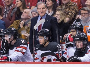 Canada head coach Tim Hunter stands on the bench during third-period world junior action against Switzerland in Vancouver on Dec. 27.