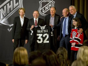 Commissioner Gary Bettman, centre left, hoists a jersey after the NHL Board of Governors announced Seattle as the league's 32nd franchise on Tuesday, Dec. 4, 2018, in Sea Island Ga. Joining Bettman, from left to right, is Jerry Bruckheimer, David Bonderman, David Wright, Tod Leiweke and Washington Wild youth hockey player Jaina Goscinski.