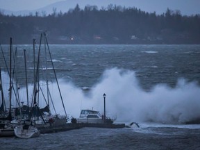 Boats are battered by waves in White Rock, B.C. Tens of thousands of people remain without power two days after a powerful windstorm.