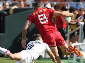 Justin Douglas (R) of Canada vies for the ball with Oliver Lindsay-Hague (L) of  England during their match in the Men's Sevens World Rugby Dubai Series on  November 30, 2018 in Dubai.