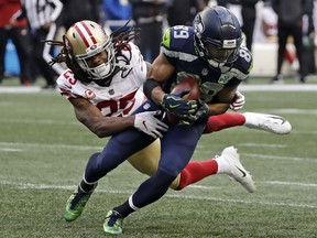 San Francisco 49ers cornerback Richard Sherman, left, tries to tackle Seattle Seahawks wide receiver Doug Baldwin during a game on Dec. 2, 2018. Baldwin was released by Seattle on Thursday.