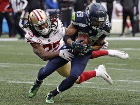 San Francisco 49ers cornerback Richard Sherman, left, tries to tackle Seattle Seahawks wide receiver Doug Baldwin during the second half of an NFL football game, Sunday, Dec. 2, 2018, in Seattle. Baldwin managed to break the tackle and gain yardage.