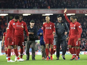 Liverpool coach Juergen Klopp (second from right) celebrates after Liverpool forward Divock Origi (second from left) scored at the end of the English Premier League soccer match against Everton at Anfield Stadium in Liverpool, England, on Sunday, Dec. 2, 2018.