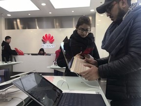 Foreigners look at a Huawei computer at a Huawei store in Beijing.
